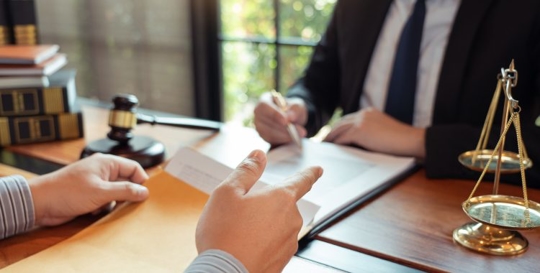 client talking with attorney at desk