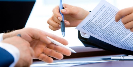 attorney hand pointing to estate planning document with client's hand holding a pen
